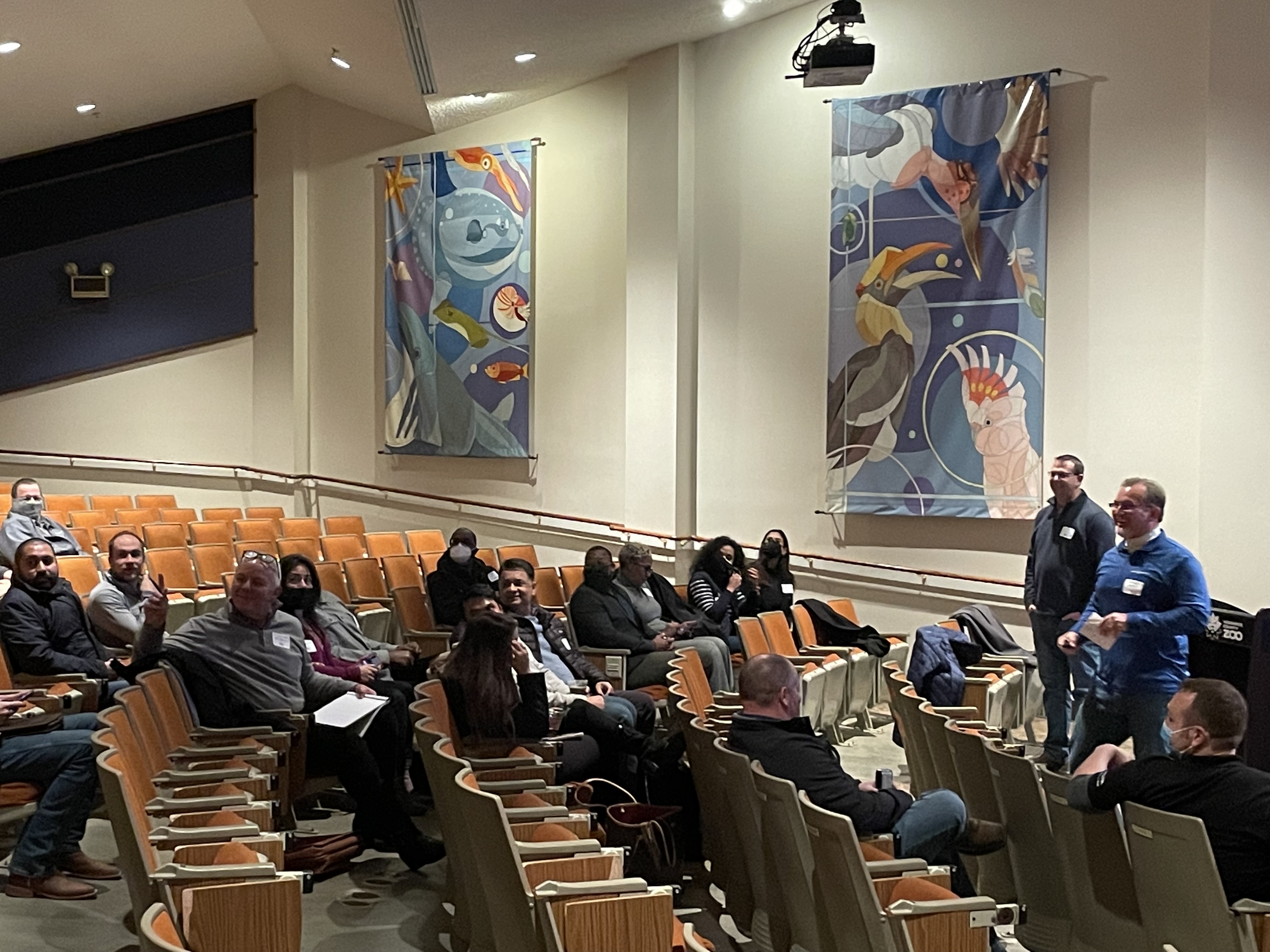 attendees at an in-person procurement and networking event in a theatre setting