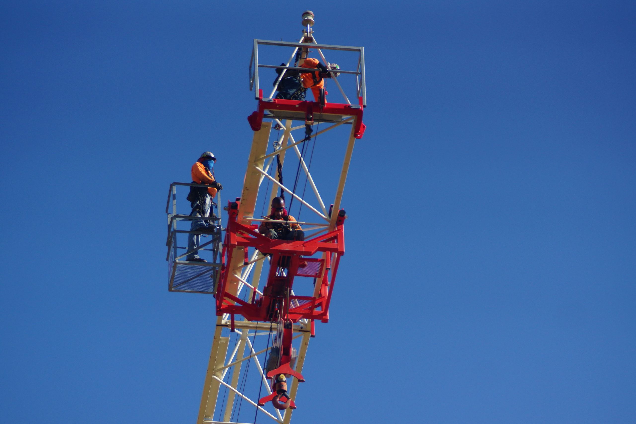 Image of tower crane and workers after the boom has been removed.